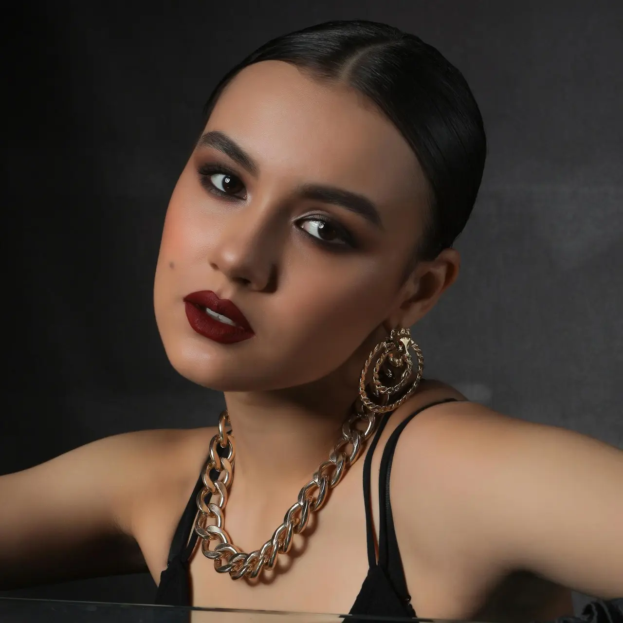 Frau mit elegantem Abend Make-up vor dunklem Hintergrund